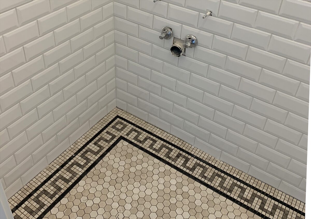 Metro-Fliesen mit handverlegtem Mosaikboden und Mäander-Bordüre